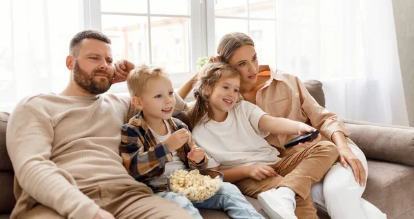 Verrukt Familie Ouders Kinderen Eten Popcorn Lachen Terwijl Zitten Bank — Stockfoto