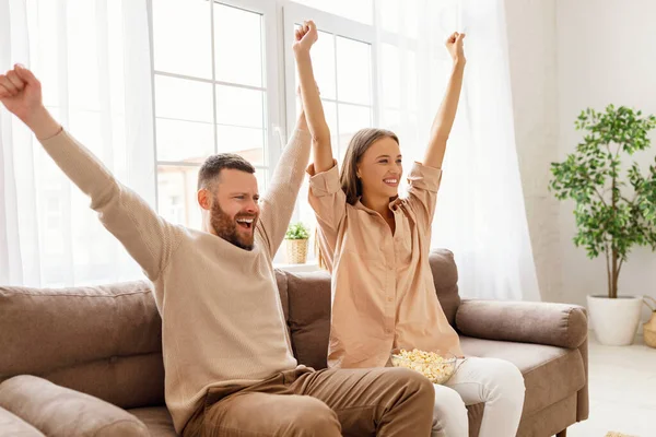 幸せな感情的なカップル悲鳴とお祝いの目標ながらソファに座ってテレビでサッカーの試合を一緒に見る — ストック写真