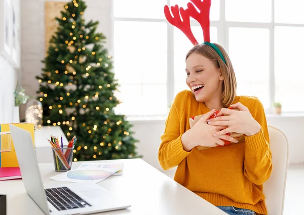 Excited Female Antlers Hugging Present Box Smiling While Speaking Online — Stock Photo, Image