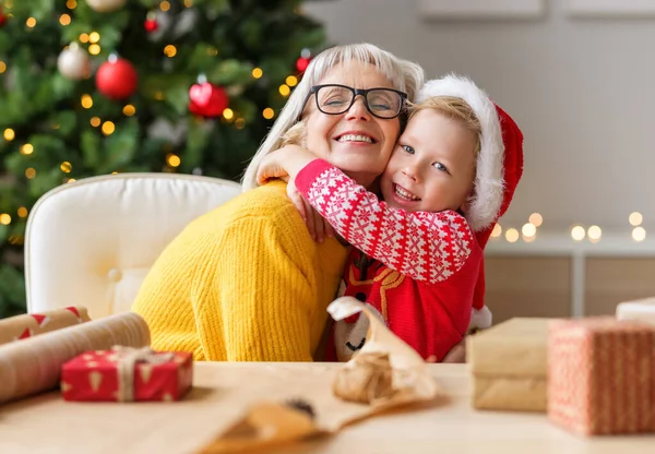 Söt Unge Kramas Glad Äldre Mormor Medan Inslagning Julklappar Nära — Stockfoto