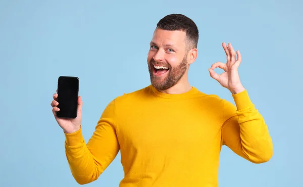 Grappige Vrolijke Man Een Gele Trui Met Smartphone Maakt Een — Stockfoto