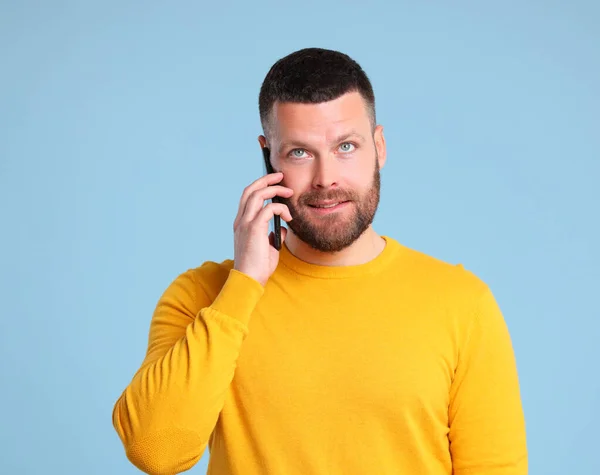 Grappige Vrolijke Man Een Gele Trui Spreken Door Smartphone Gekleurde — Stockfoto