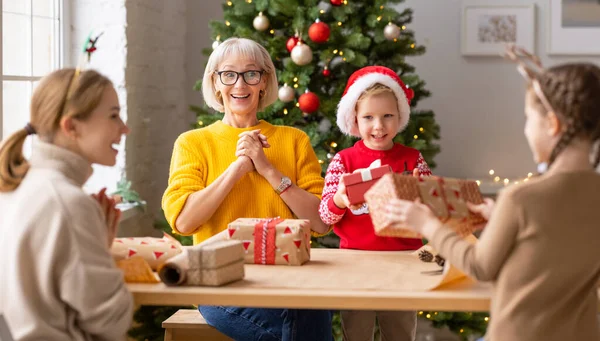 Mulheres Encantadas Crianças Embrulhando Presentes Natal Juntos Enquanto Reúnem Mesa — Fotografia de Stock
