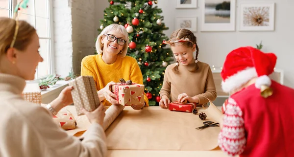 Mujeres Niños Encantados Envolviendo Regalos Navidad Juntos Mientras Reúnen Mesa — Foto de Stock