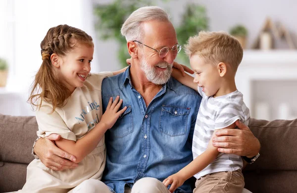 Fröhlich Gealterter Mann Lächelt Und Umarmt Süße Jungen Und Mädchen — Stockfoto