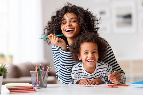Neşeli Etnik Kadın Gülerken Mutlu Çocuğa Ödevlerini Yapması Için Yardım — Stok fotoğraf