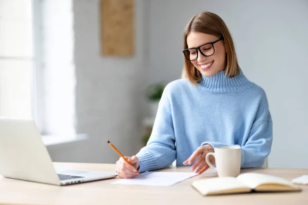 Jovem Freelancer Feliz Sorrindo Examinando Papéis Enquanto Senta Mesa Trabalha — Fotografia de Stock