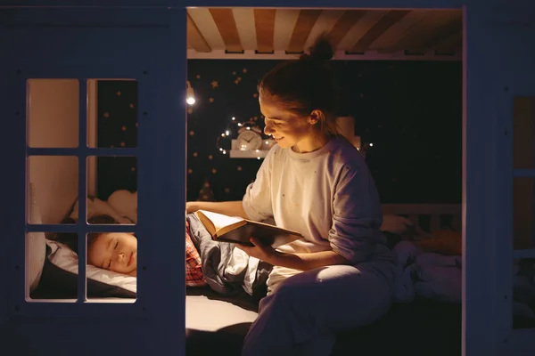 Mulher Alegre Sorrindo Lendo Conto Fadas Para Dormir Menina Enquanto — Fotografia de Stock