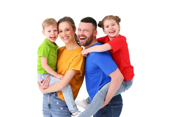 スタジオの白い背景に立ち カメラを見るさまざまな色のTシャツを着た笑顔の両親と子供 — ストック写真