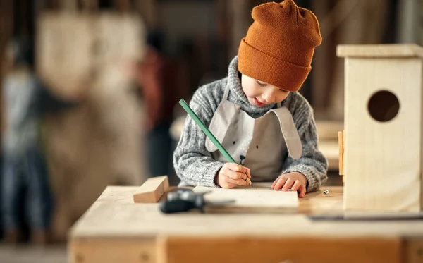 Konzentrierter Kleiner Junge Zeichnet Skizze Auf Holzplanke Beim Bau Von — Stockfoto