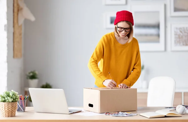 Cheerful Female Entrepreneur Stylish Clothes Glasses Smiling Writing Address Carton — Stock Photo, Image