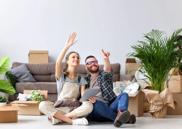 Cheerful Couple Sitting Floor Tablet Unpacked Boxes While Discussing Decoration — Stock Photo, Image