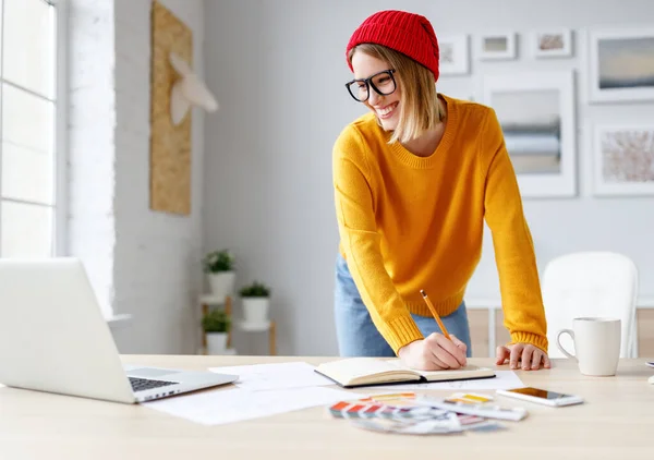 Jovem Feliz Sorrindo Para Laptop Escrevendo Planejador Enquanto Inclina Mesa — Fotografia de Stock