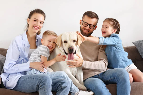 快乐的家庭 父母带着快乐的孩子在家里和他们最喜欢的宠物狗拉布拉多玩耍 — 图库照片