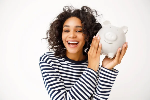 幸せな民族の女性ともに巻き毛笑いとショーPiggy銀行とともにお金とともに灰色の背景 — ストック写真