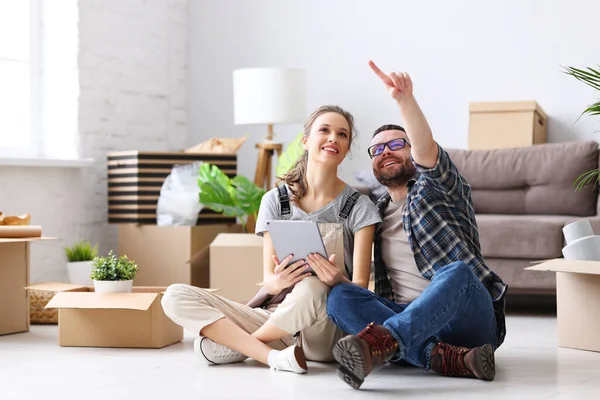 Cheerful Couple Sitting Floor Tablet Unpacked Boxes While Discussing Decoration — Stock Photo, Image