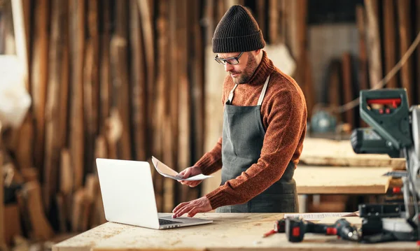 Concentrated Adult Bearded Craftsman Paper Hand Checking Information Laptop While — Stock Photo, Image