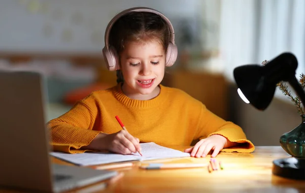 Petite Écolière Positive Dans Casque Écriture Dans Copybook Pendant Les — Photo