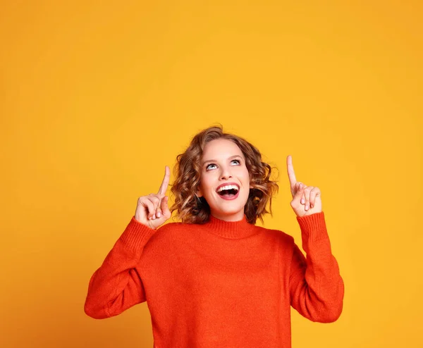 Entzückte Junge Frau Trendigen Orangefarbenen Pullover Lächelt Und Zeigt Nach — Stockfoto