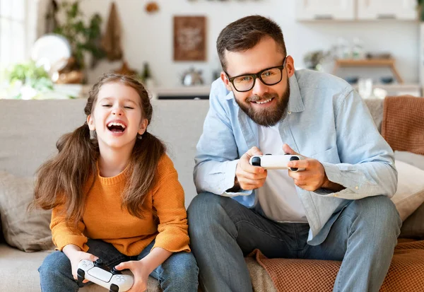幸せな家庭の父と娘がビデオゲーム機を使って一緒に笑い — ストック写真