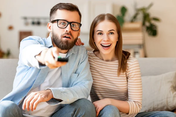 Pareja Sorprendida Hombre Con Control Remoto Mujer Emocionada Sentada Sofá — Foto de Stock