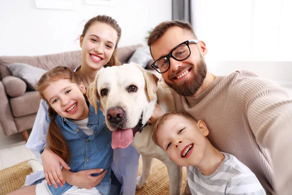 快乐的父母带着可爱的孩子和可爱的纯种狗 一边在家里玩耍一边拥抱和拥抱 — 图库照片