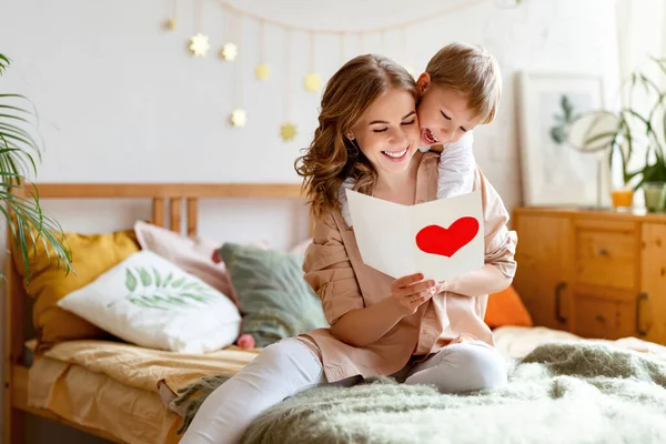 Vrolijke Moeder Knuffelen Zoon Het Lezen Van Handgemaakte Wenskaart Met — Stockfoto