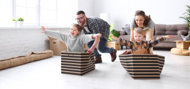 Neşeli aile: Çocuklar kutulara biniyor ve yeni bir daireye taşınırken eğleniyorlar.