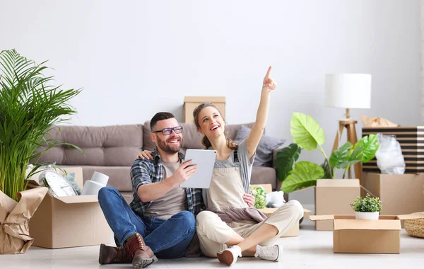 Cheerful Couple Sitting Floor Tablet Unpacked Boxes While Discussing Decoration — Stock Photo, Image