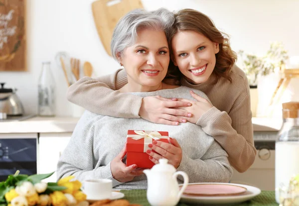 Mujer Joven Alegre Abrazando Feliz Anciana Hembra Dando Flores Caja —  Fotos de Stock