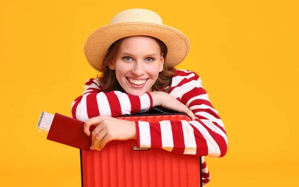 旅行の概念 スーツケースとパスポートを持つ陽気な若い女性が黄色の背景で微笑む — ストック写真