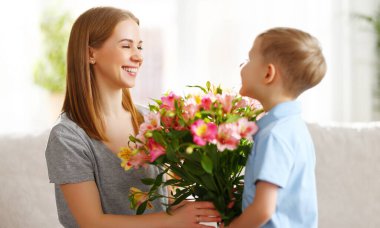 8 Mart 'ta annesine bir buket Alstroemeria çiçeği veren tatlı çocuğun yan görüntüsü.