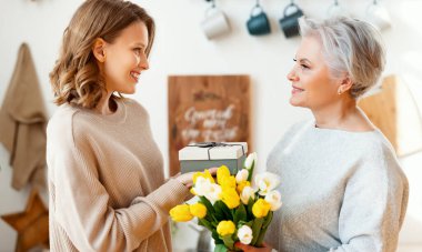 Bir sürü taze lalesi olan zarif, yaşlı bir kadın anneler günü kutlamalarında küçük bir kızın hediyesini kabul ediyor.