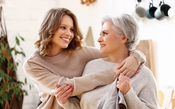 Cheerful Young Woman Hugging Aged Mother Sitting Sofa While Resting — Stock Photo, Image