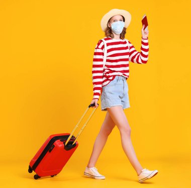 Sıradan giysiler içinde tanınmayan genç bir yolcunun tüm vücudu ve biletleri ve pasaportu olan bir yüz maskesi, sarı bir arka planda bavulla yürüyordu.  