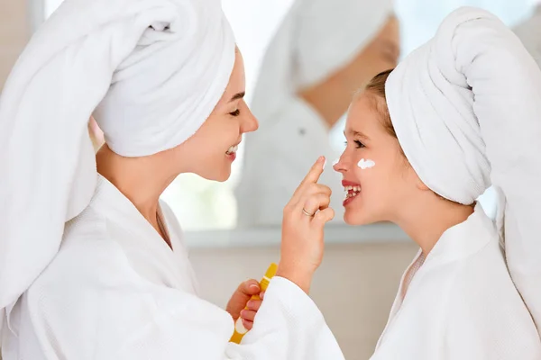 Vista Lateral Mujer Sonriente Tocando Nariz Hija Riente Aplicando Crema — Foto de Stock