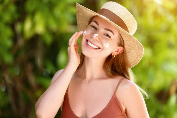 Lächelnde Frau Badeanzug Mit Strohhut Und Schmierender Sonnencreme Gesicht Die — Stockfoto