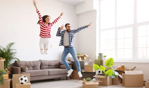Full body of happy young energetic couple having fun and jumping high while enjoying new home after relocation