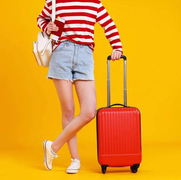 夏天旅行的概念 穿着短裤 车票和红色行李箱的女腿 衬托着明亮的黄色底色 — 图库照片