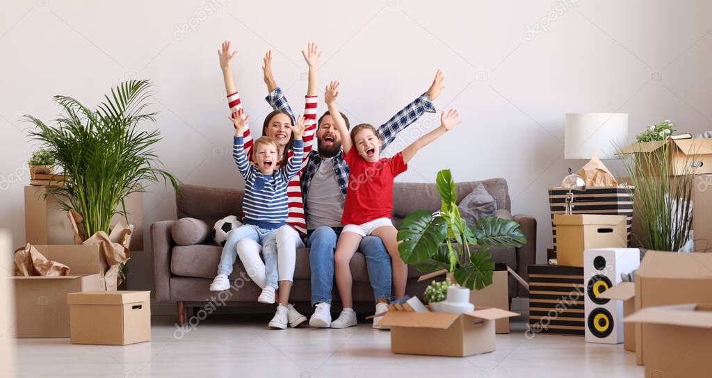 Full body optimistic parents and kids raising arms and screaming in excitement while sitting on couch in new flat