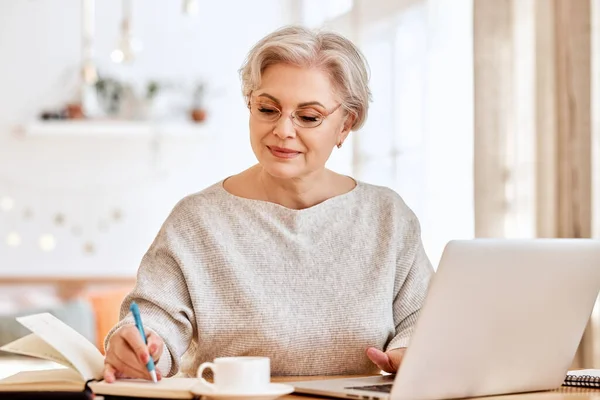 Senior Vrouw Met Laptop Notebook Terwijl Zitten Aan Tafel Werken — Stockfoto