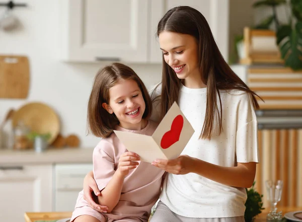 Ευτυχισμένη Νεαρή Γυναίκα Αγκαλιάζει Κορίτσι Και Διαβάζοντας Ευχετήρια Κάρτα Καρδιά — Φωτογραφία Αρχείου