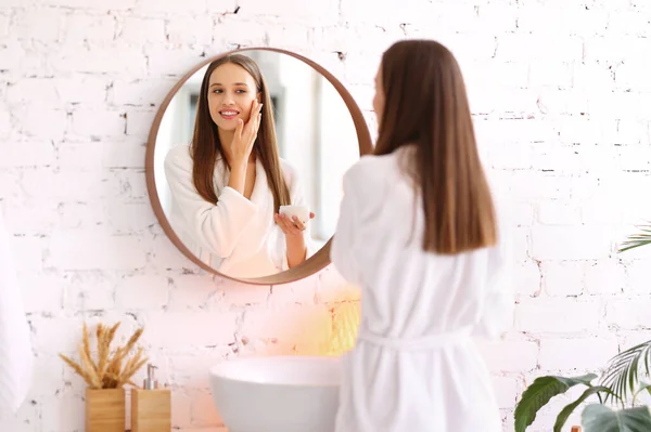 Charming Young Female White Bathrobe Standing Mirror Touching Face While — Photo