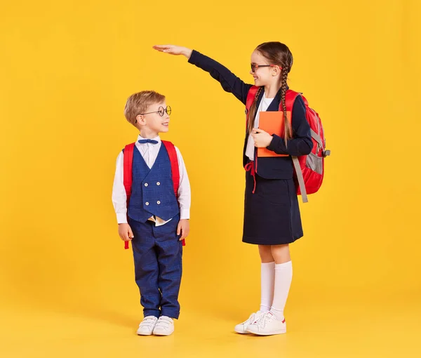 教育发展和成长的概念 穿着校服 背着书包 站在黄色背景下 身披校服 身材矮小 快乐的学龄前女学生 — 图库照片