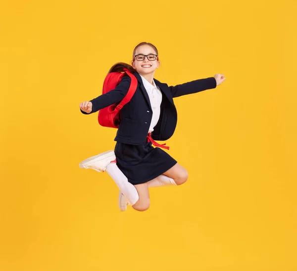 Siyah Üniformalı Sırt Çantalı Sarı Arka Planda Zıplayan Mutlu Bir — Stok fotoğraf