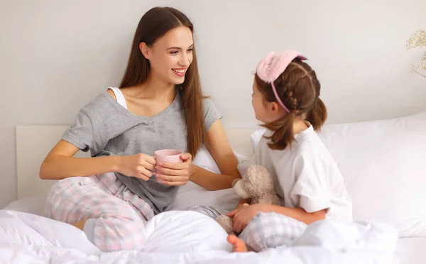 Mutlu Aile Genç Anne Güzel Kız Sıcak Içeceklerle Sabahları Yatakta — Stok fotoğraf