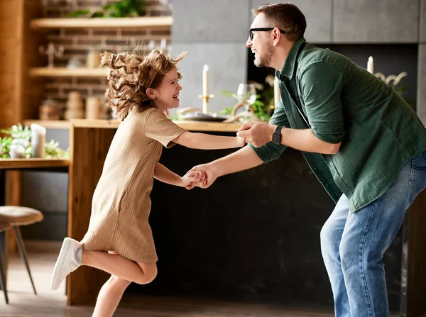 パパと楽しんでる カジュアルウェアダンスでかわいい興奮した女の子と若い遊び心のある父親の完全な足は 自宅のリビングルームに立っている間に一緒に踊っています 家族のレジャー活動 — ストック写真