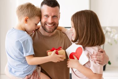 Küçük çocuklar babalarına kırmızı kalpli ve gülümseyen bir kartpostal yolluyor, aile tatilini mutfakta birlikte kutluyorlar. Babalar Günü konsepti