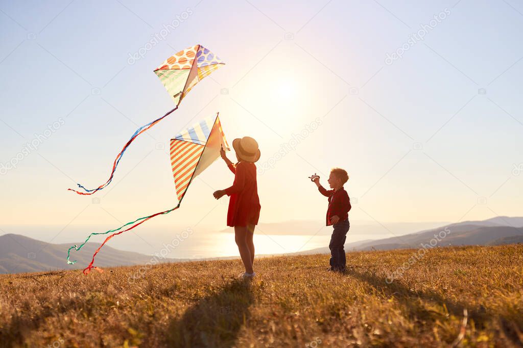 happy kids sister and brother launches a kite at sunset on nature outdoors
