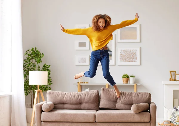 Freiheit Genießen Überglückliche Junge Afroamerikanerin Freizeitkleidung Die Wohnzimmer Springt Und — Stockfoto